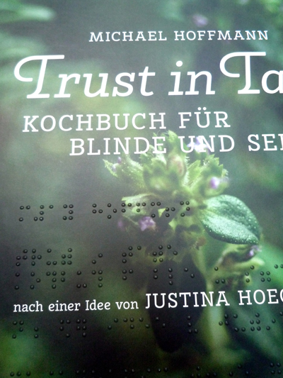 Kochbuch Cover mit Punktschrift "Trust in Taste"